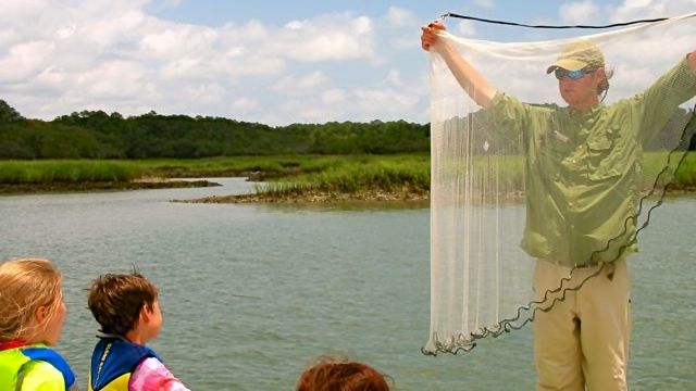 Captain Blair shows fishing cast net to kids